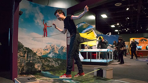 Visitors balance on the Highline Challenge exhibit at Frost Science