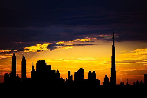 a vibrant sunset silhouette of the Dubai skyline