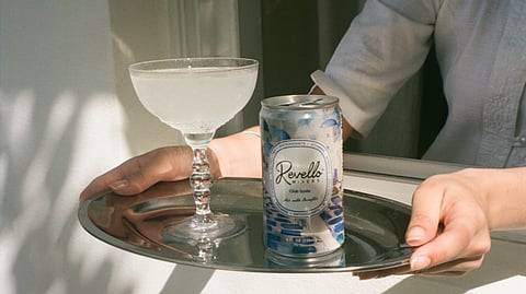 Tray holding a cocktail and Revello Modern Mixers club soda can