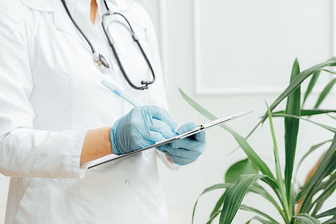 a medical professional writing on a clipboard