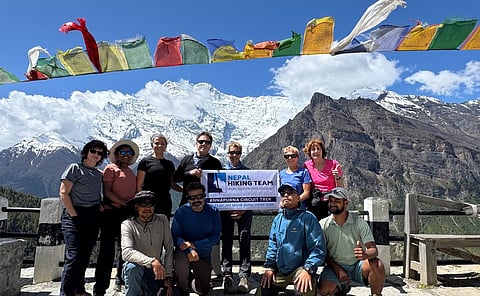 a group of trekkers holding a banner for the Nepal Hiking Team