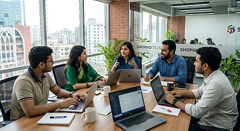 Team of five colleagues meeting at a table with laptops