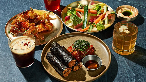 A spread of LALAON Korean barbecue dishes, cocktails, and seasonal vegetables