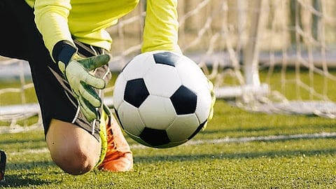 Goalkeeper reaching for a soccer ball