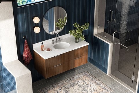 Modern luxury bathroom with wooden vanity, glass shower, round mirror, and dark blue walls