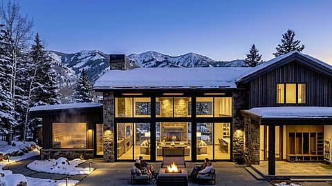 Snowy luxury mountain home with an outdoor fire pit