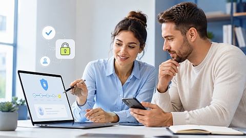 Two professionals reviewing online security settings on a laptop and smartphone.