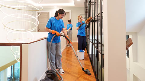 Professional cleaners sanitizing a modern home's interior with specialized equipment