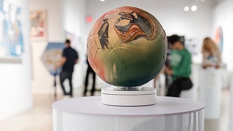 Hand-painted World Cup soccer ball by Lili Cantero displayed in a Wynwood gallery