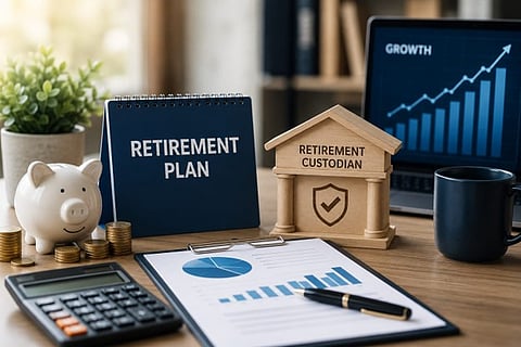 A retirement plan document on a desk alongside a calculator, piggy bank, and laptop