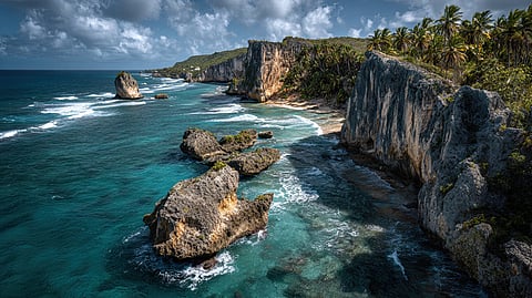A rocky tropical coastline with steep cliffs overlooking turquoise water.