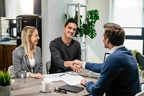Couple shaking hands with agent
