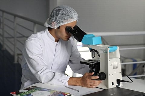 Scientist looking through a microscope.