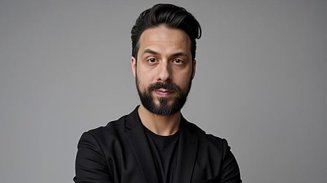 Man with a beard in a black suit.