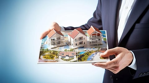 Man holding miniature houses.