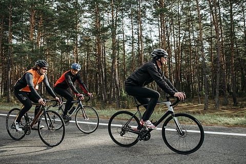 Three cyclists on a forest road.