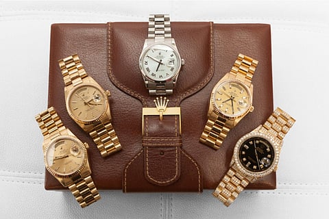 Five watches on a leather case.