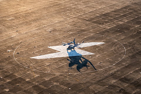 BETA ALIA electric aircraft resting on a charging pad at a flight test facility.