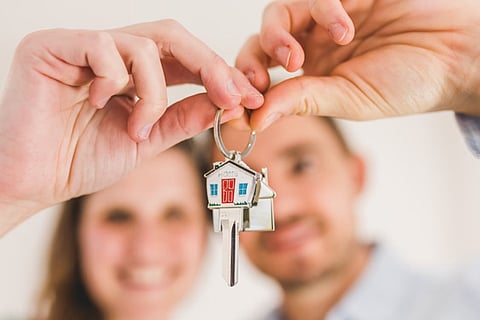 Couple holding a house key.