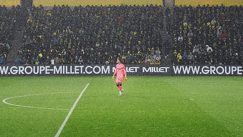 Soccer player in a rainy stadium.