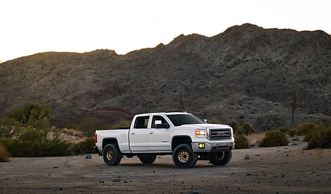 White GMC pickup truck in a desert.