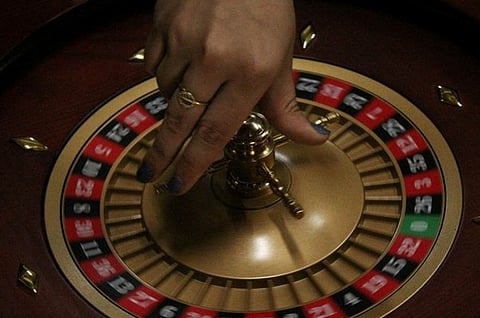 Hand on roulette wheel.