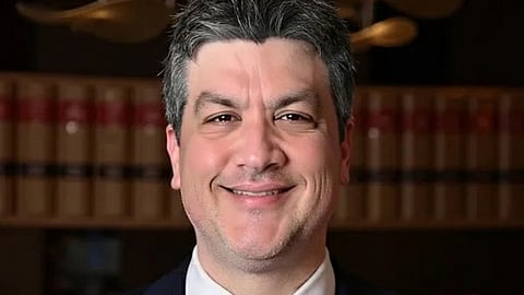Smiling man in a suit and tie.