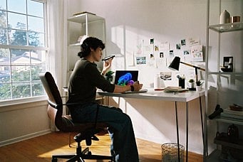 Person at desk using smartphone.