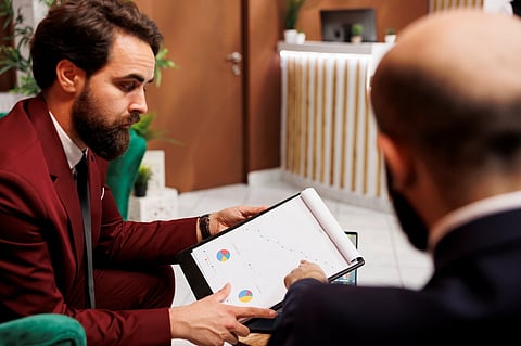 Two men reviewing charts.
