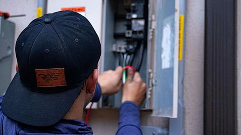 Man working on an electrical panel.