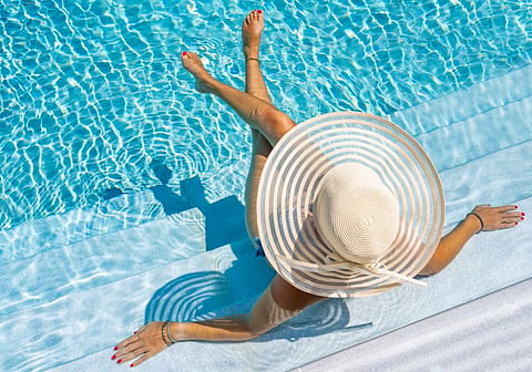 Woman in pool with white hat