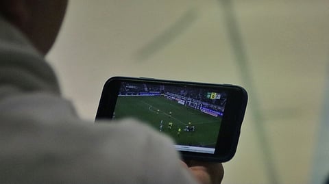 Person watching soccer on a smartphone.