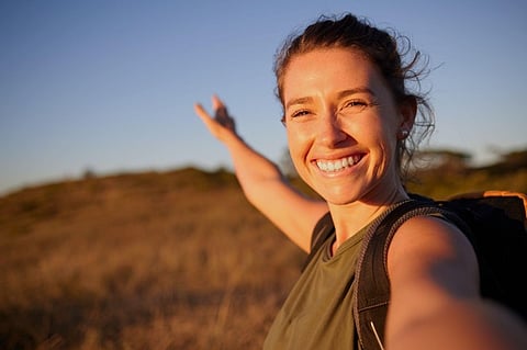 Smiling female hiker at sunset.