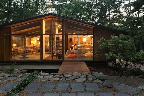 Modern glass house exterior at dusk.