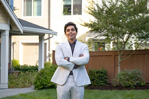 Smiling man in a suit outdoors.