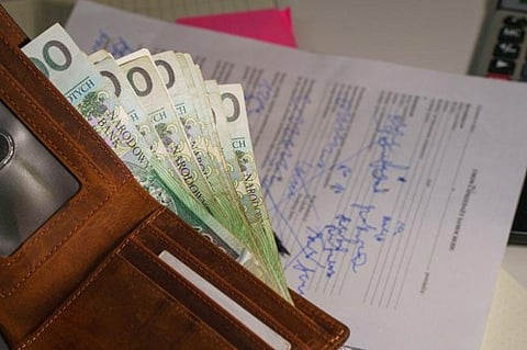 Wallet full of cash on a document.