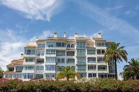 White apartment building with palm trees.
