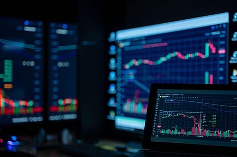 Multiple monitors displaying financial charts.