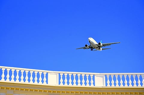 Airplane flying above a white balustrade