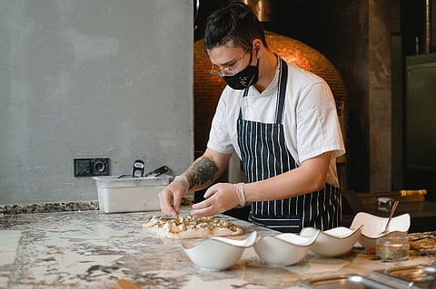 Chef preparing pizza.