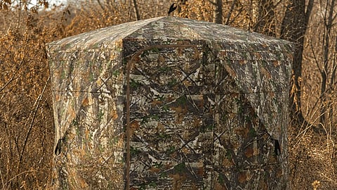 Camouflage hunting blind in the woods.