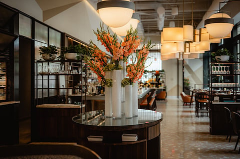 Restaurant interior with a floral arrangement, pendant lights and dining tables