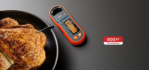 Roasted chicken next to a digital meat thermometer.