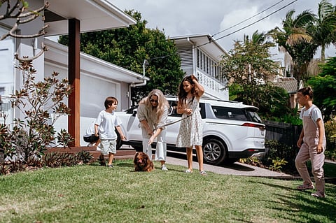 Family with a dog in a front yard.