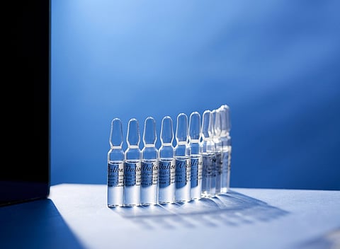 Row of glass ampoules on a blue background.