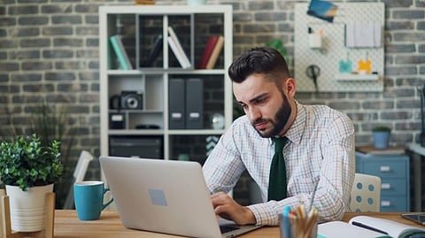 Man working on laptop at desk.