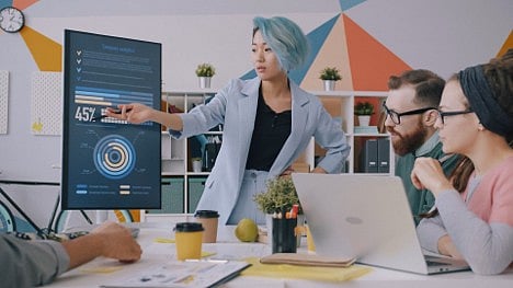 Woman presenting data dashboard to colleagues.