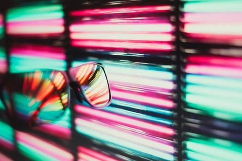 Sunglasses reflecting neon lights