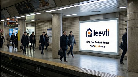 Commuters passing a leevli billboard in a subway station.