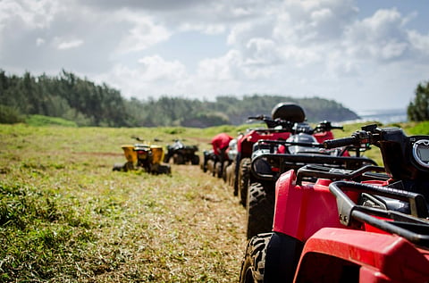 ATVs on a grassy path.